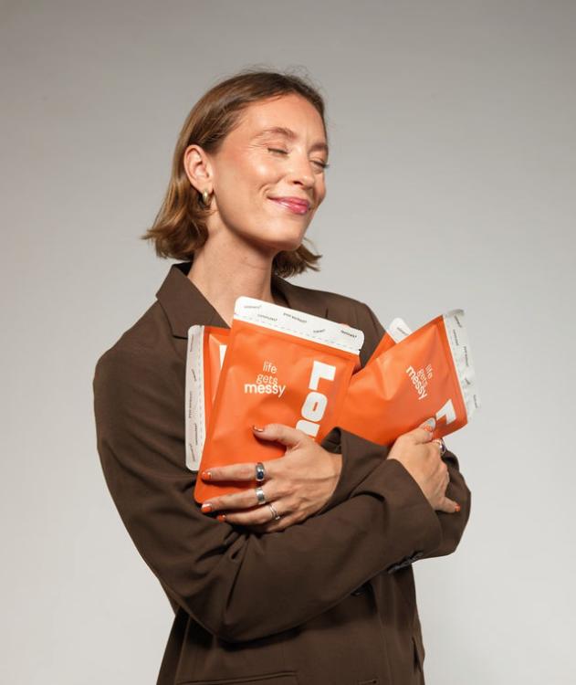 Sacha Rose Cramer holding packs of Louie wipes